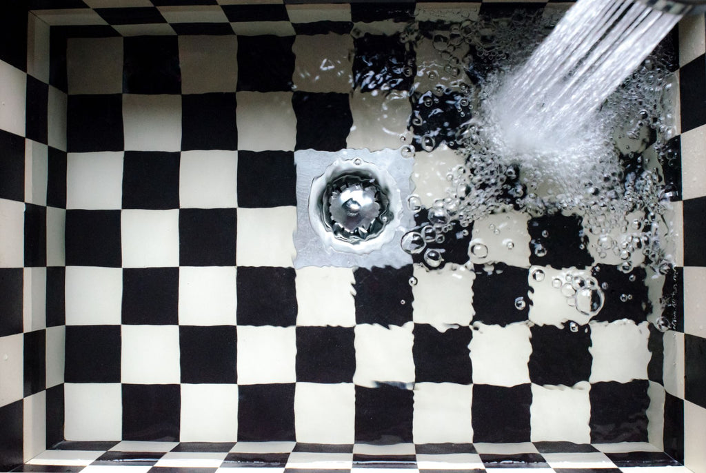 Top view of a checkered sink with water splashing, showcasing elegant design